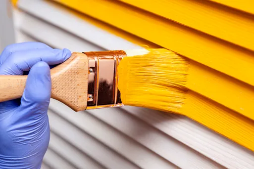 Brushing yellow onto siding boards